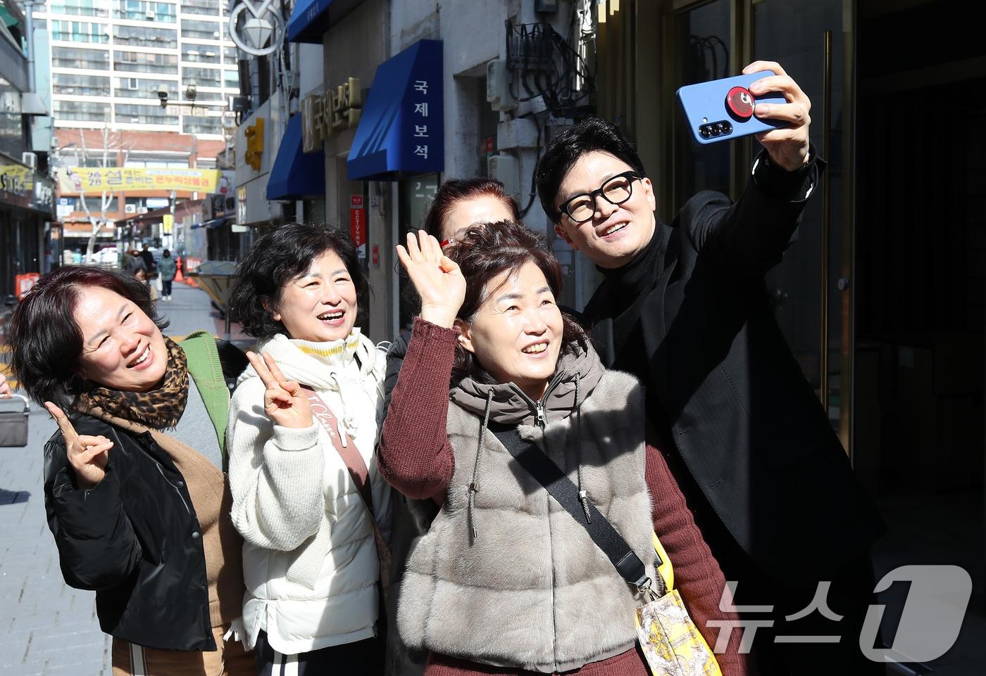 본문 이미지 - 한동훈 전 국민의힘 대표가 25일 오후 대구 중구 교동 패션주얼리특구를 찾아 시민들의 요청에 함께 기념촬영을 하고 있다. 2026.2.25 ⓒ 뉴스1 공정식 기자