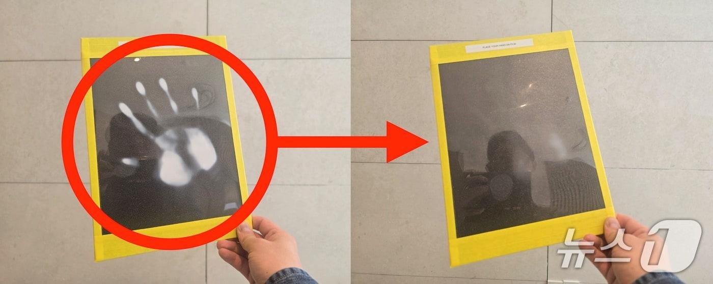 본문 이미지 - 재료연구원과 한국남부발전이 공동 개발 중인 BIPV(건물일체형 태양광) 시연제품 모습. 손바닥을 필름에 가져다 대자 색이 밝게 변했다. 건물 외벽이나 창호에 설치, 광반응을 이용해 에너지를 생산할 수 있다는 설명이다. ⓒ 뉴스1 황덕현 기자