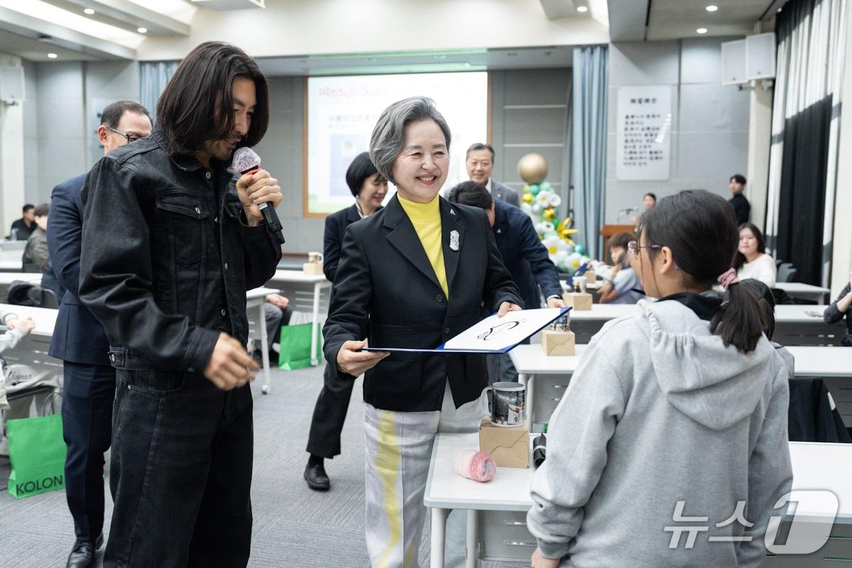 본문 이미지 - 코오롱그룹 비영리 재단법인 꽃과어린왕자의 서창희(가운데) 이사장이 캠프 참가 어린이에게 장학증서를 전달하는 모습. (사진제공 = 코오롱그룹) 