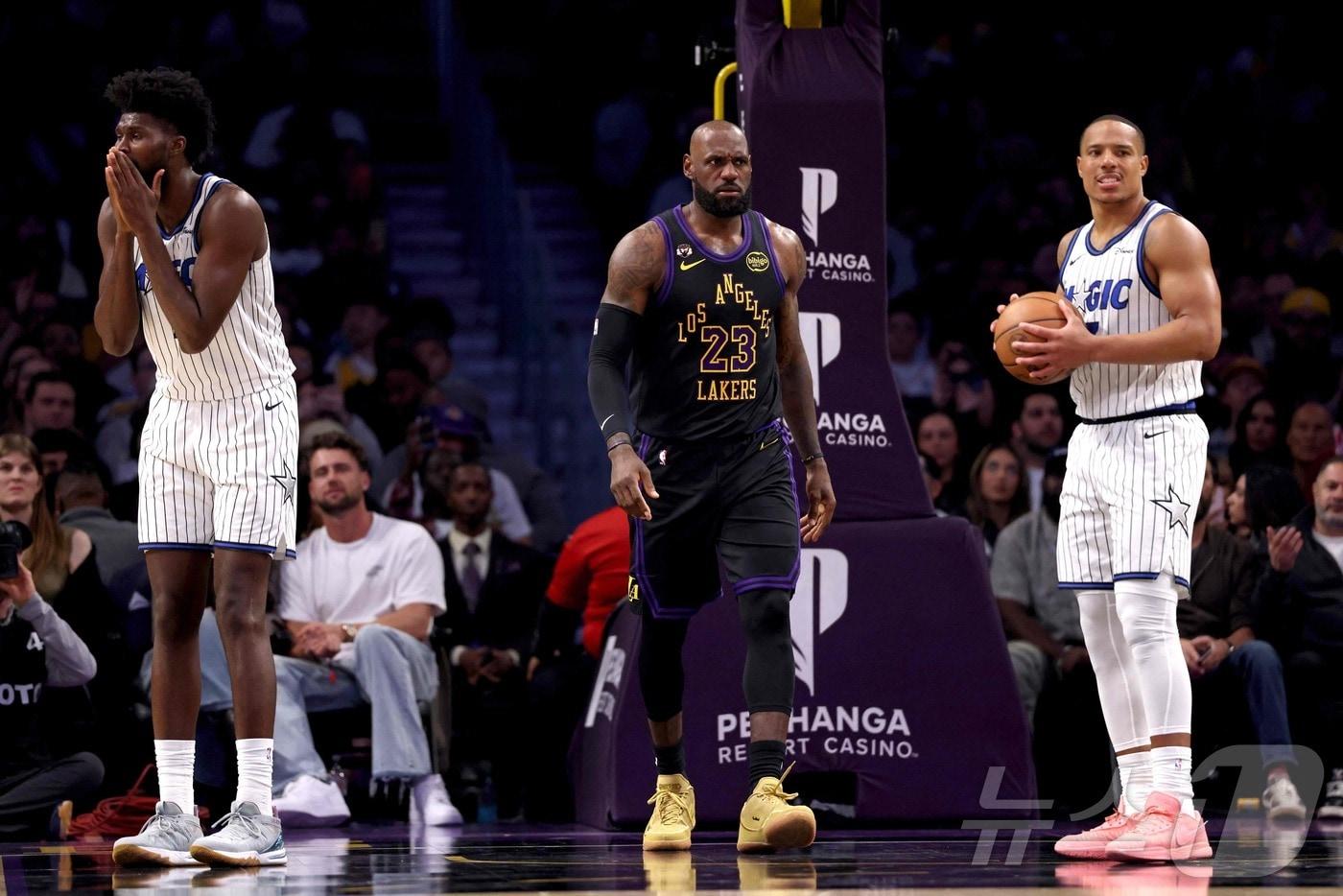 본문 이미지 - LA 레이커스 르브론 제임스(가운데)는 25일(한국시간) 열린 2025-26 NBA 정규리그 올랜도 매직전에서 뼈아픈 자유투 실패로 팀 패배를 막지 못했다. ⓒ AFP=뉴스1
