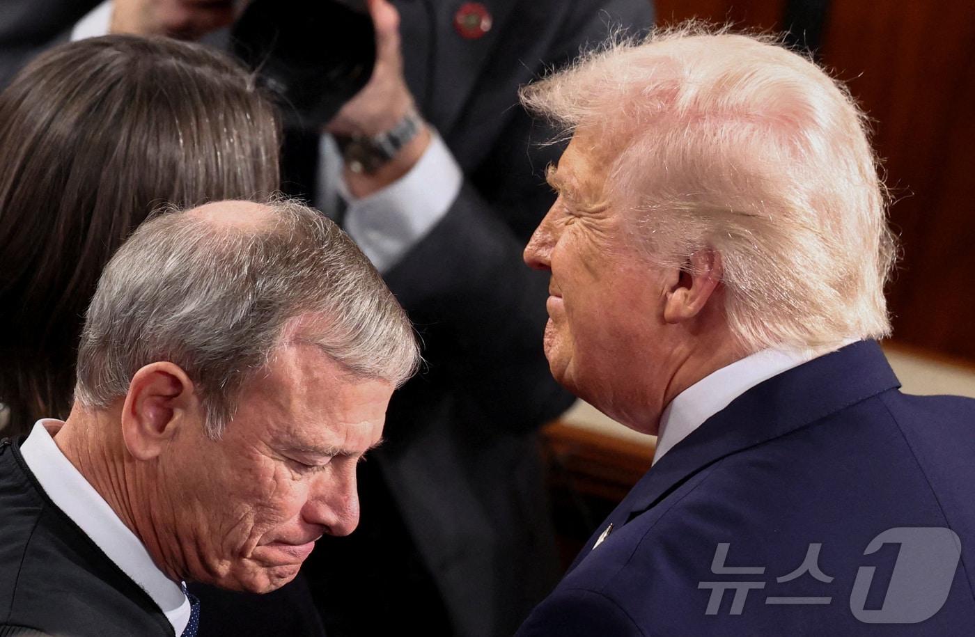 본문 이미지 - 도널드 트럼프 미국 대통령(오른쪽)이 24일 워싱턴DC 의사당에서 국정연설을 하기 전에 연방대법원 대법관들과 조우하고 있다. 왼쪽은 존 로버츠 대법원장. 2026.2.24 ⓒ 로이터=뉴스1