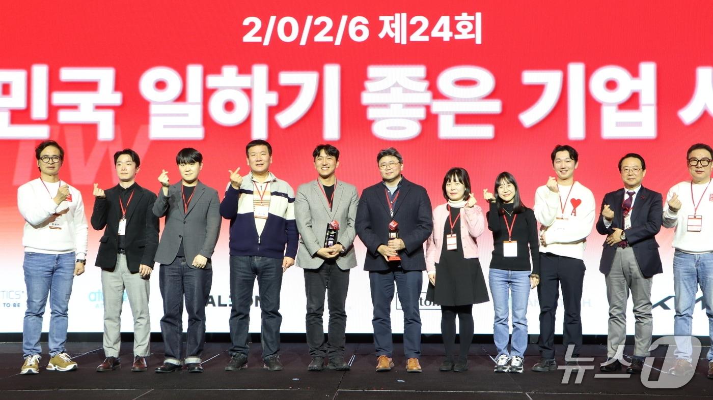 본문 이미지 - 25일 서울 여의도 콘래드 호텔에서 열린 'GPTW 경영 혁신 콘퍼런스'에서 기아 관계자를 비롯한 수상자들이 '대한민국 일하기 좋은 100대 기업' 선정을 기념해 사진 촬영하는 모습(기아 제공) 2026.2.26/뉴스1