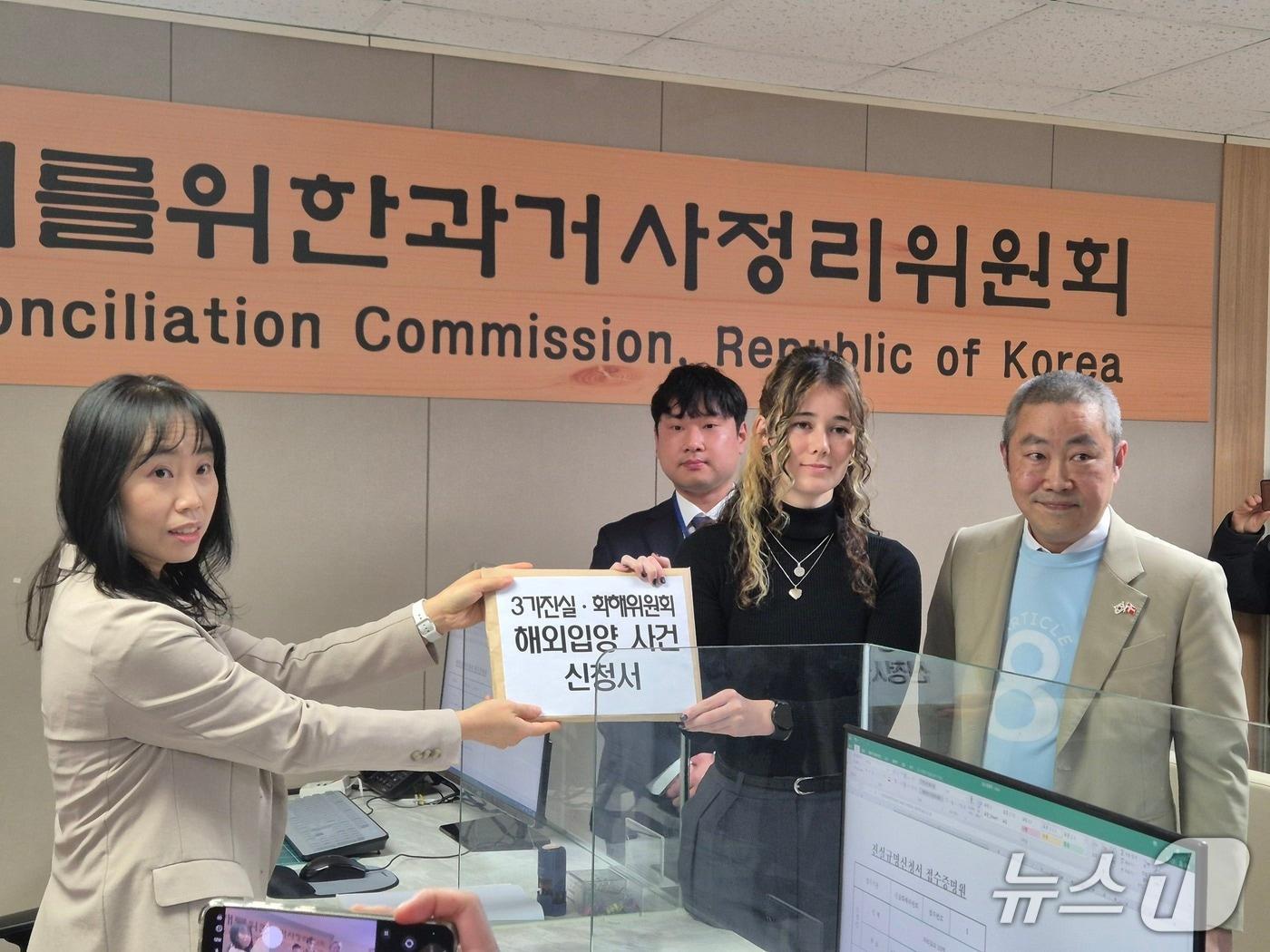 본문 이미지 - 해외입양인 2세인 마릿 킴 씨와 피터 뮐러 뿌리의집 공동대표가 해외 입양 사건 진실규명 신청서를 접수하고 있다. 2026.2.26 ⓒ 뉴스1 신윤하 기자