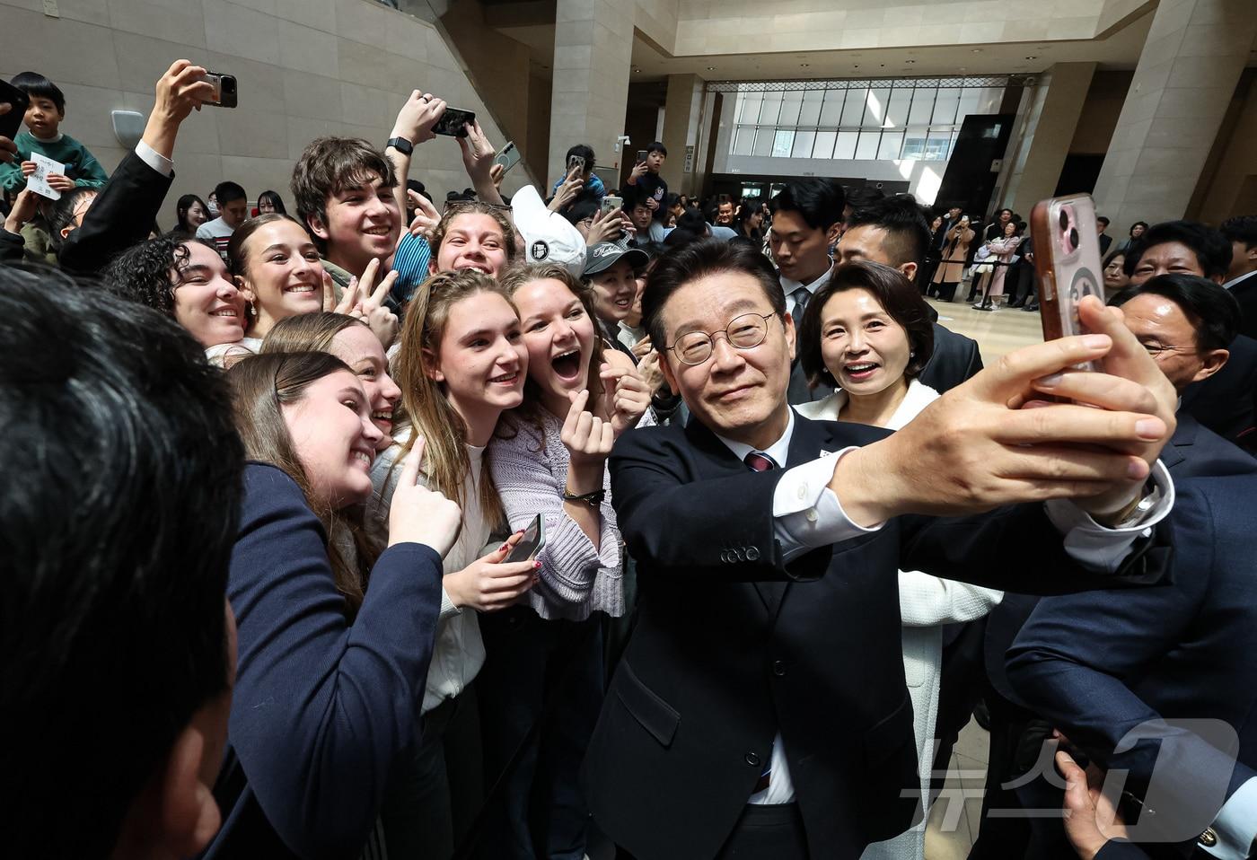 본문 이미지 - 이재명 대통령과 김혜경 여사가 26일 서울 용산구 국립중앙박물관에서 열린 특별전 '우리들의 이순신'을 관람한 뒤 외국인 관광객들과 기념촬영을 하고 있다. 2026.2.26 ⓒ 뉴스1 허경 기자