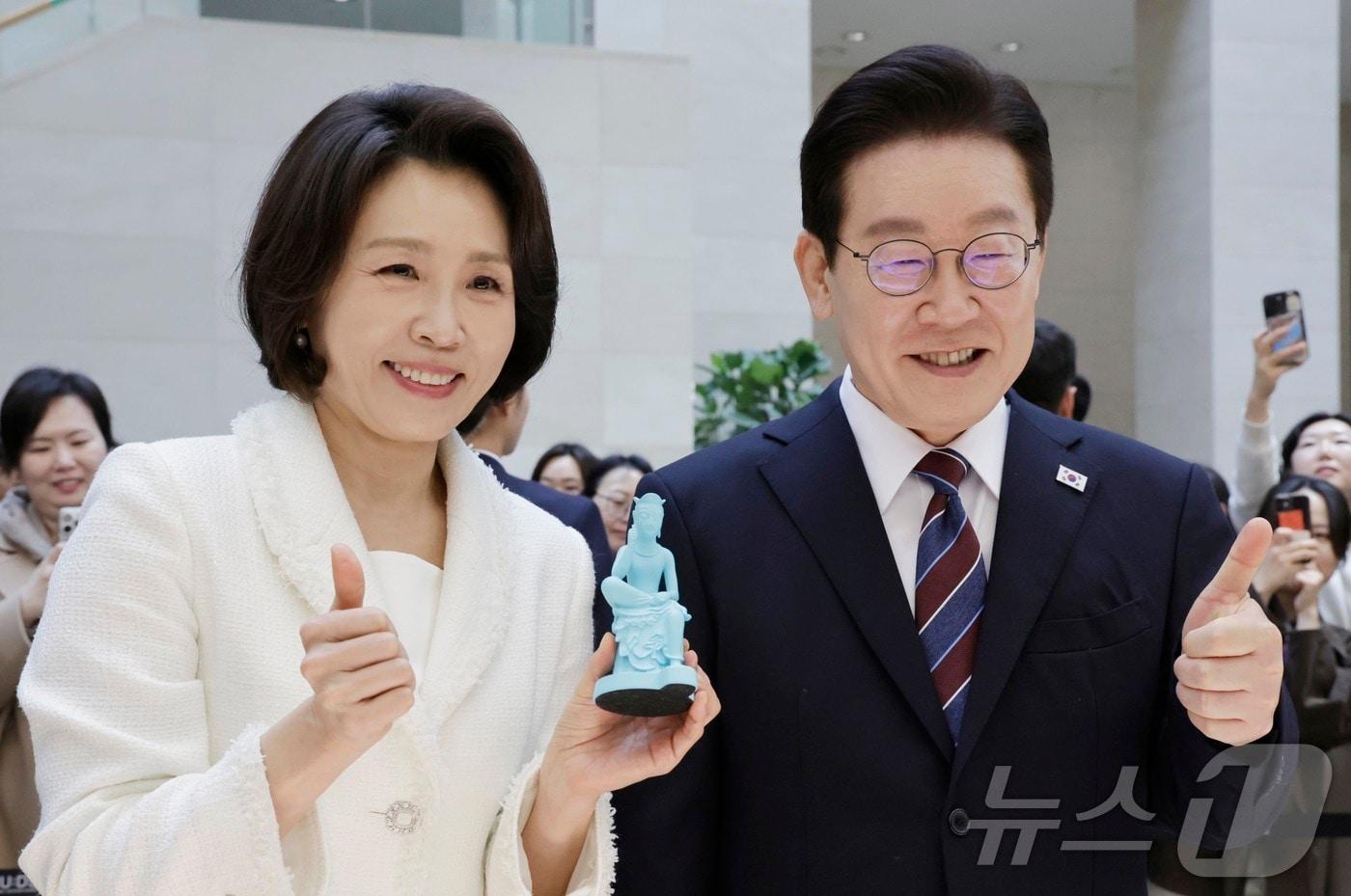 본문 이미지 - 이재명 대통령과 김혜경 여사가 26일 서울 용산구 국립중앙박물관에서 열린 특별전 '우리들의 이순신'을 관람한 뒤 기념품을 들고 기념촬영을 하고 있다. 2026.2.26 ⓒ 뉴스1 허경 기자