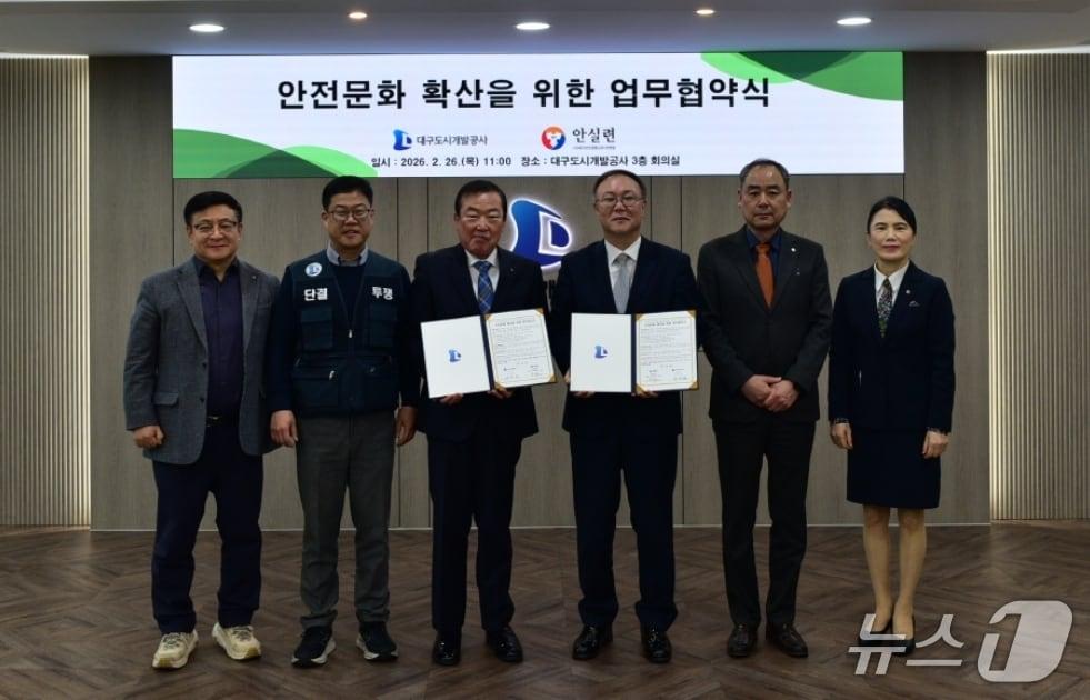 본문 이미지 - 정명섭 대구도시개발공사 사장(왼쪽 세번째)과 박주현 대구안전생활실천시민연합 공동대표(오른쪽 세번째)가 안전문화 확산을 위한 업무협약을 체결한 뒤 협약서를 펼쳐 보이고 있다.(대구도시개발공사 제공, 재판매 및 DB 금지)