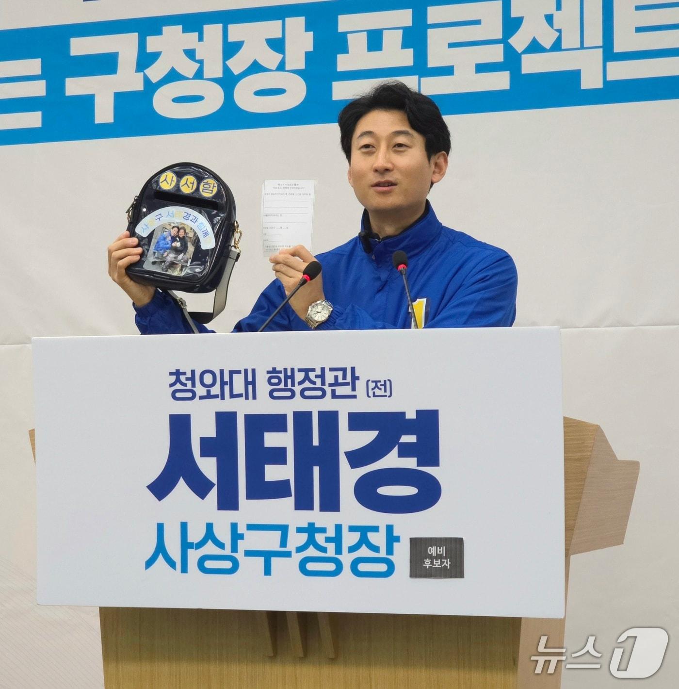 본문 이미지 - 서태경 사상구청장 예비후보가 민생 청취 접수함인 '사서함' 가방을 보여주며 선거방법에 대해 설명하고 있다.2026.2.26/뉴스1 ⓒ News1 이주현 기자