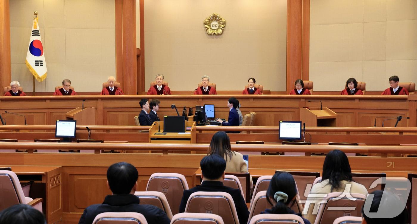 본문 이미지 - 김상환 헌법재판소장과 재판관들이 26일 서울 종로구 헌법재판소에서 열린 출입국 관리 '안면 이미지 등 생체정보 활용' 헌법소원 결론 등 2월 심판사건 선고를 위해 대심판정에 참석하고 있다. 2026.2.26 ⓒ 뉴스1 이호윤 기자