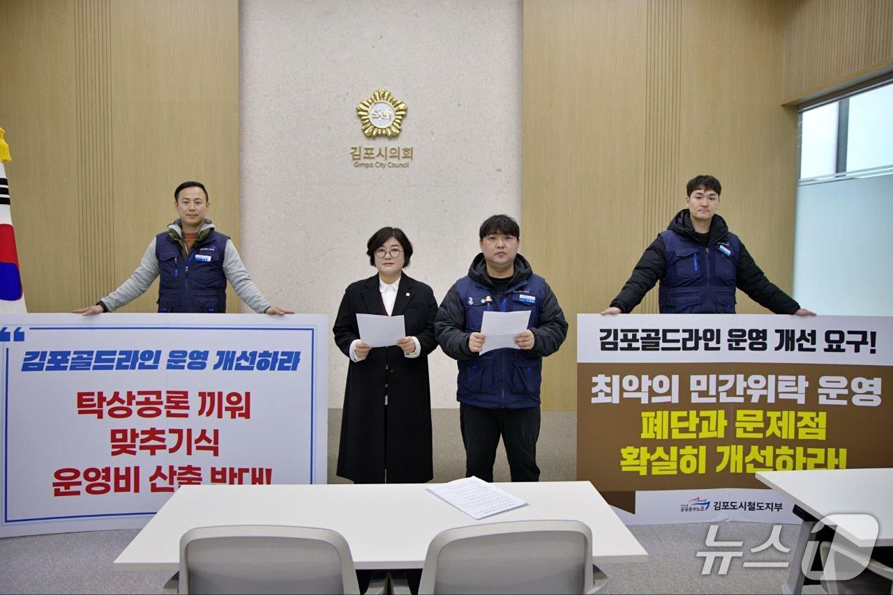 본문 이미지 - 김계순 김포시의원(왼쪽에서 두번째)가 26일 전국공공운수노조 김포골드라인지부와 함께 김포골드라인SRS의 계약 금액 부불리기 의혹과 관련한 진상규명을 촉구하고 있다(전국공공운수노조 김포골드라인지부 제공/뉴스1)