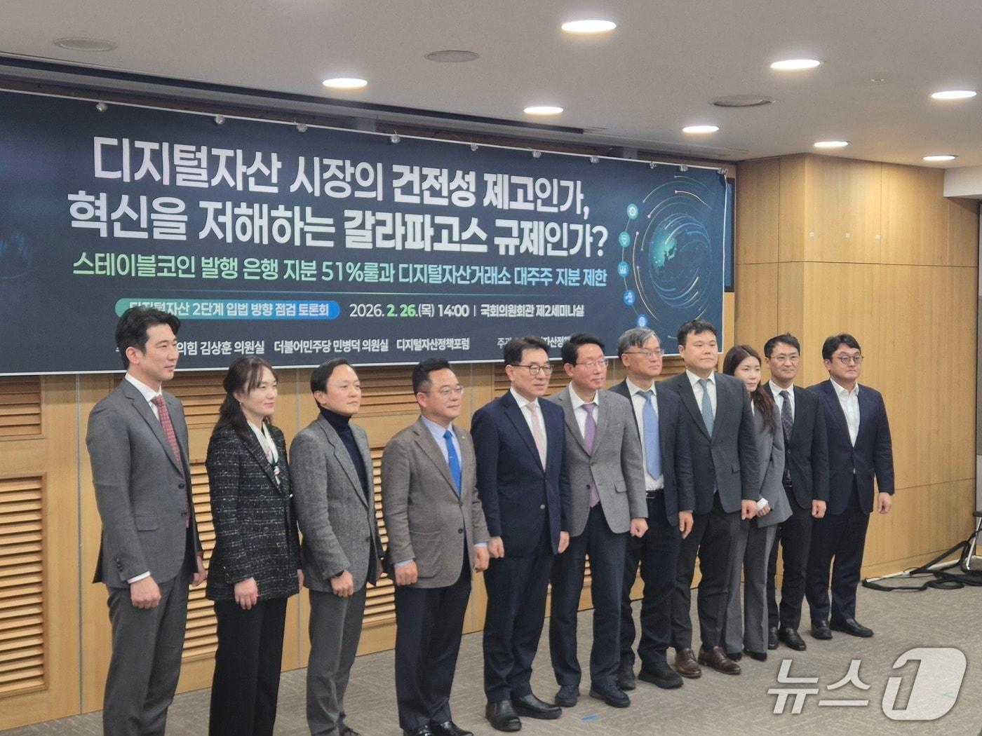 본문 이미지 -  26일 서울 여의도 국회의사당에서 열린 '디지털자산 2단계 입법 점검 토론회' 참석자들이 기념 촬영을 하고 있다. 2026.2.26./뉴스1