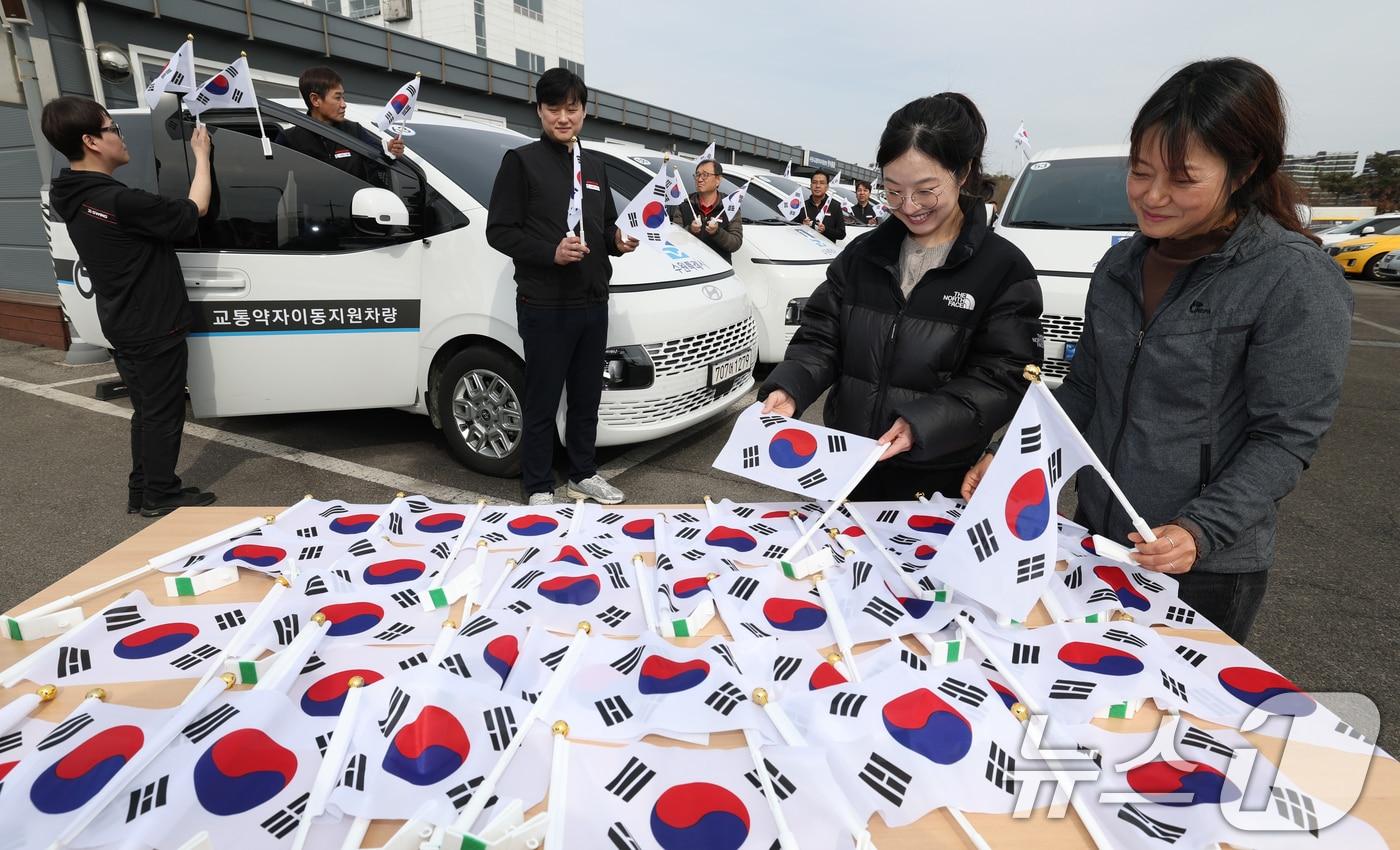 본문 이미지 - 제107주년 3·1절을 사흘 앞둔 26일 경기 수원시 권선구 수원시교통약자지원센터 한아름콜에서 직원들이 3·1절을 맞아 교통약자지원차량에 부착할 태극기를 준비하고 있다. 2026.2.26 ⓒ 뉴스1 김영운 기자