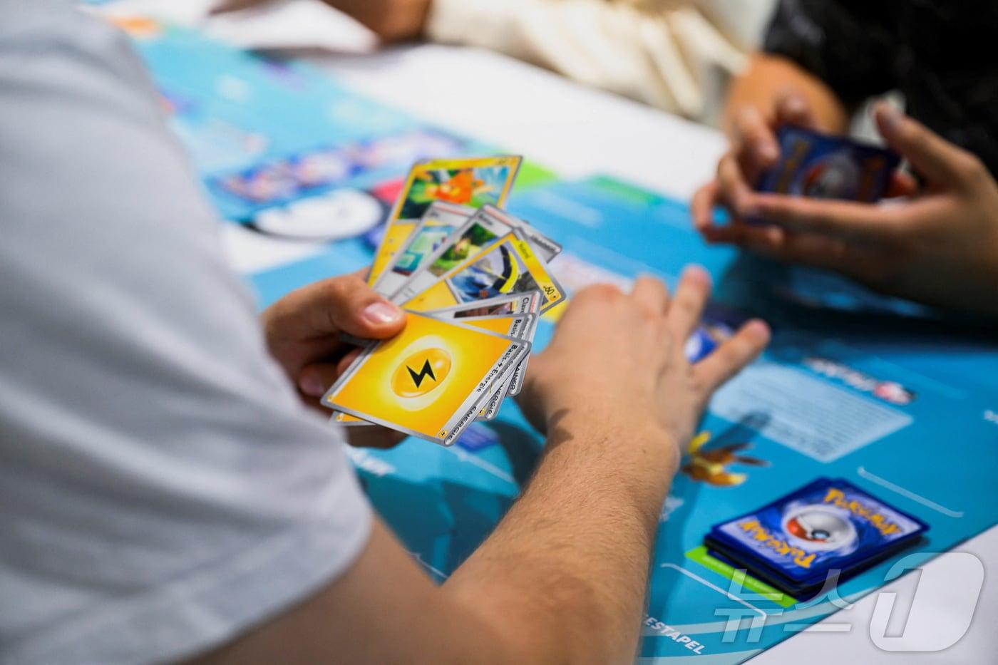 본문 이미지 - 포켓몬 카드 게임을 즐기고 있는 사람들 <자료사진> ⓒ 로이터=뉴스1