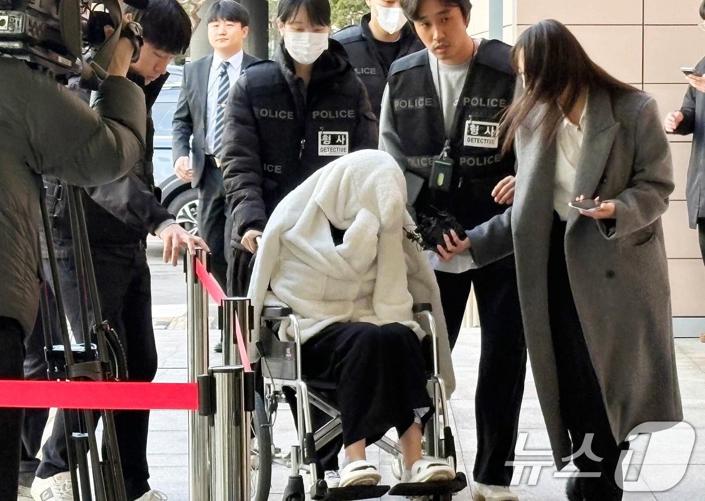 본문 이미지 - 약물을 투약한 상태로 차량을 몰다 반포대교 난간을 뚫고 추락한 30대 여성 A씨가 27일 서울서부지법에서 열린 구속 전 피의자 심문(영장실질심사)에 휠체어를 타고 출석하고 있다. A씨는 지난 25일 오후 8시 44분쯤 포르쉐 SUV를 몰고 반포대교를 달리다 난간을 들이받고 잠수교 인근 한강 둔치로 추락한 혐의를 받는다. 2026.2.27 ⓒ 뉴스1 소봄이 기자