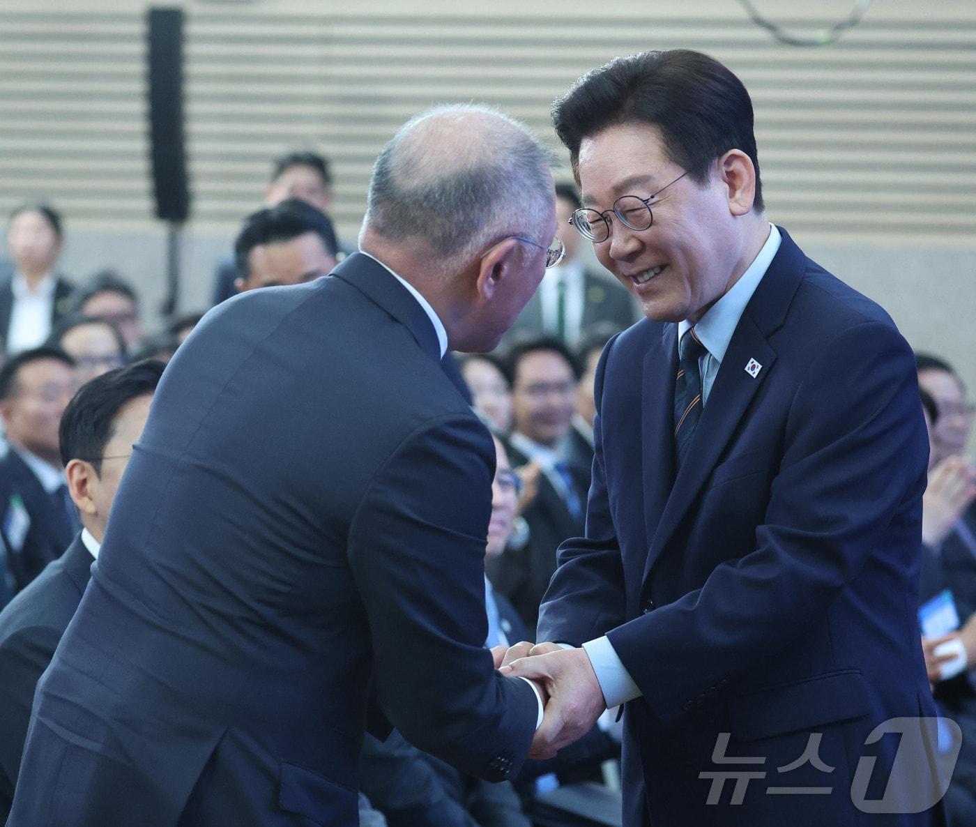본문 이미지 - 이재명 대통령이 27일 전북 군산시 새만금 컨벤션센터에서 열린 새만금 로봇·수소·AI 시티 투자협약식에서 정의선 현대자동차 회장과 악수를 하고 있다. 2026.2.27 ⓒ 뉴스1 이재명 기자