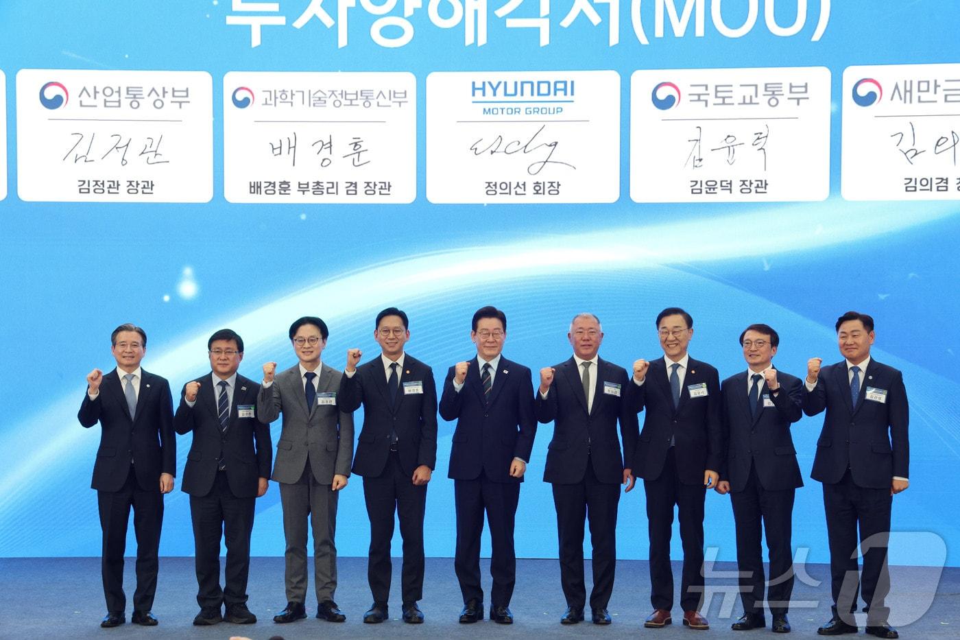 본문 이미지 - 이재명 대통령과 정의선 현대자동차 회장이 27일 전북 군산시 새만금 컨벤션센터에서 열린 새만금 로봇·수소·AI 시티 투자협약식에서 투자협약을 체결한 뒤 기념촬영을 하고 있다. 왼쪽부터 김용범 정책실장, 김성환 기후에너지환경부 장관, 김정관 산업통상부 장관, 배경훈 부총리 겸 과학기술정보통신부 장관, 이재명 대통령, 정의선 현대자동차 회장, 김윤덕 국토교통부 장관, 김의겸 새만금청장, 김관영 전북도지사. 2026.2.27 ⓒ 뉴스1 이재명 기자