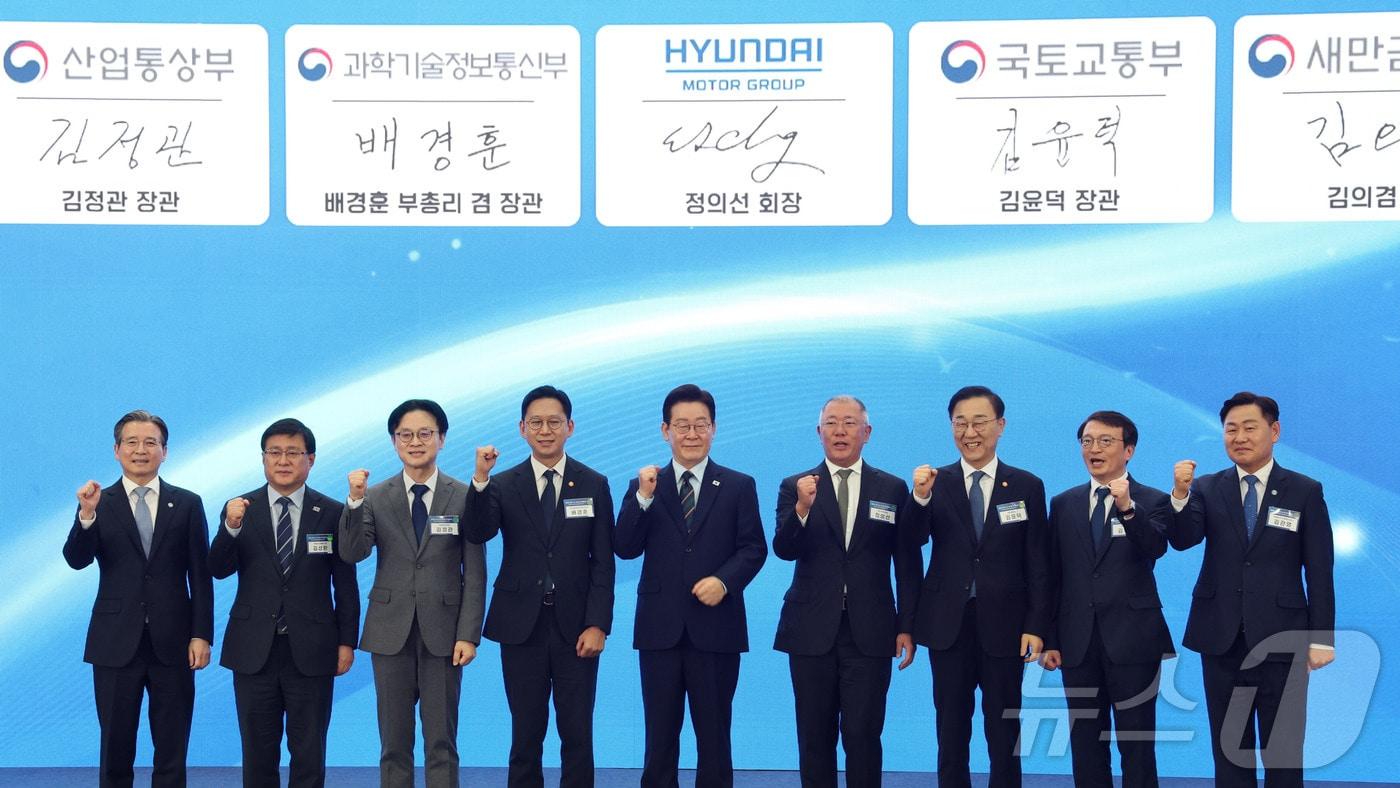 본문 이미지 - 이재명 대통령과 정의선 현대자동차 회장이 27일 전북 군산시 새만금 컨벤션센터에서 열린 새만금 로봇·수소·AI 시티 투자협약식에서 투자협약을 체결한 뒤 기념촬영을 하고 있다. 왼쪽부터 김용범 정책실장, 김성환 기후에너지환경부 장관, 김정관 산업통상부 장관, 배경훈 부총리 겸 과학기술정보통신부 장관, 이재명 대통령, 정의선 현대자동차 회장, 김윤덕 국토교통부 장관, 김의겸 새만금청장, 김관영 전북도지사. 2026.2.27 ⓒ 뉴스1 이재명 기자