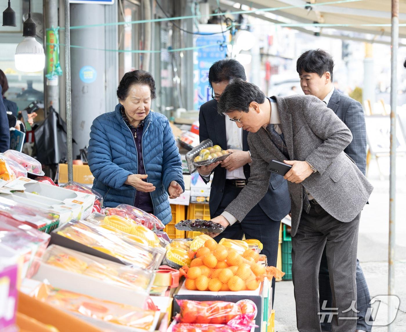 본문 이미지 - 김돈곤 충남 청양군수가  기본소득 지급 첫날인 27일 관내 전통시장 등을 방문해 선불카드로 과일을 구매하고 있다. (청양군 제공, 재판매 및 DB금지) / 뉴스1