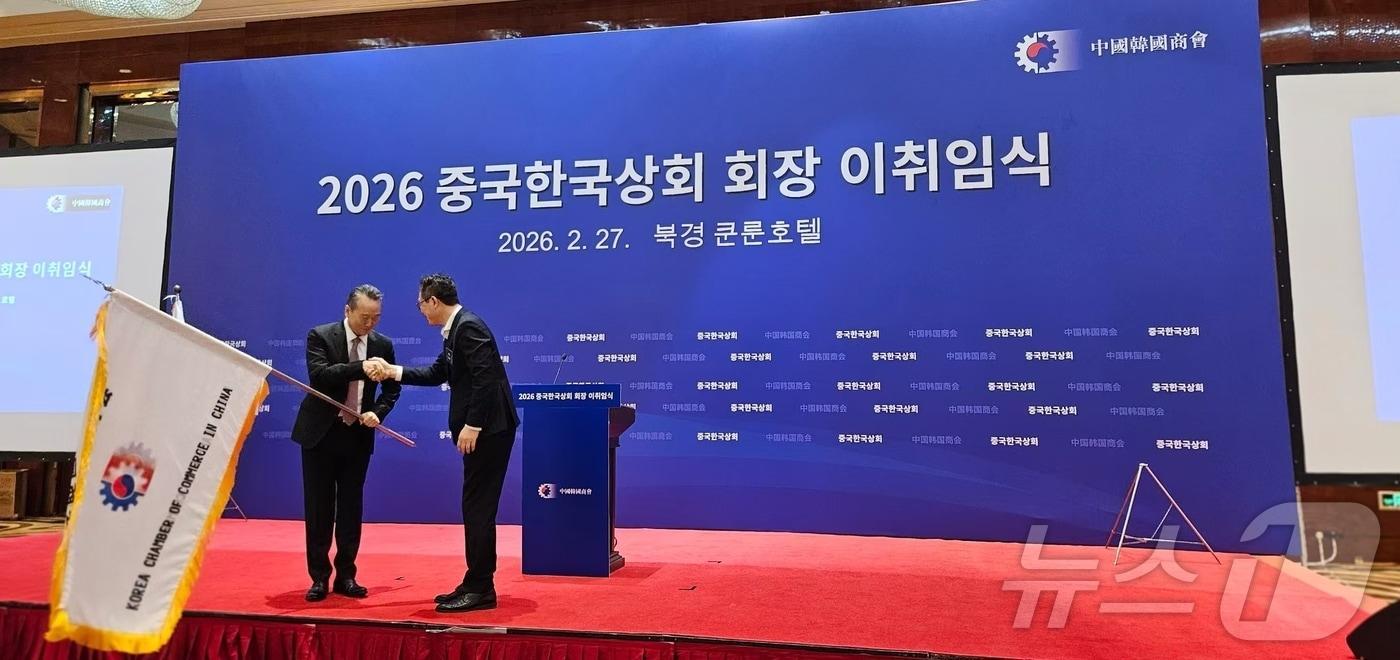 본문 이미지 - 27일 베이징 쿤룬호텔에서 개최된 중국 한국상회 회장 이취임식에서 양걸 삼성전략협력실 사장이자 전임 회장이 이혁준 현대차 중국법인 총재 겸 신임 회장에 회기를 전달하고 있다. ⓒ 뉴스1 정은지 특파원
