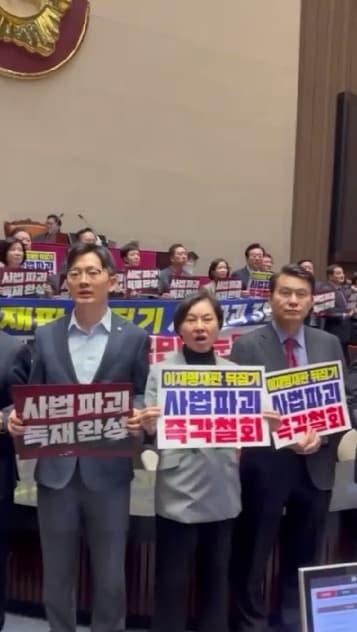 본문 이미지 - 이해민 조국혁신당 의원이 27일 오후 국회 본회의장 내에서 촬영한 영상 갈무리. 서명옥 국민의힘 의원(가운데)이 영상을 촬영하는 이 의원을 향해 "초상권 침해예요"라고 말한 뒤 다가와 손팻말을 내리치는 듯한 모습이 담겼다(조국혁신당 제공).