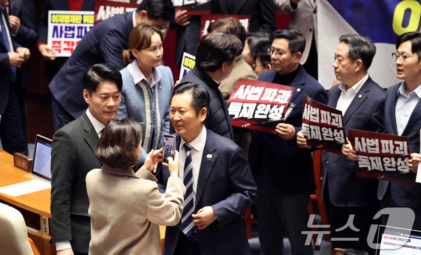 본문 이미지 - 27일 서울 여의도 국회에서 열린 제432회 국회(임시회) 제8차 본회의에서 재판소원제 도입을 골자로 하는 헌법재판소법 일부개정법률안(대안)에 대한 무제한토론 종결 투표가 진행되는 가운데 정청래 더불어민주당 대표가 사법 3법과 관련 규탄 피켓 농성하는 국민의힘 의원들을 지나고 있다. 2026.2.27 ⓒ 뉴스1 이승배 기자