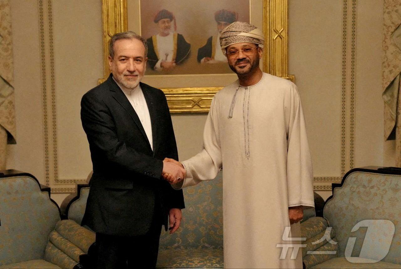 본문 이미지 - 6일(현지시간) 바드르 알부사이디 오만 외무장관(오른쪽)과 아바스 아라그치 이란 외무장관이 오만 수도 무스카트에서 만나 악수하고 있다. 사진은 이란 외무부 제공. 2026.02.06 ⓒ 로이터=뉴스1