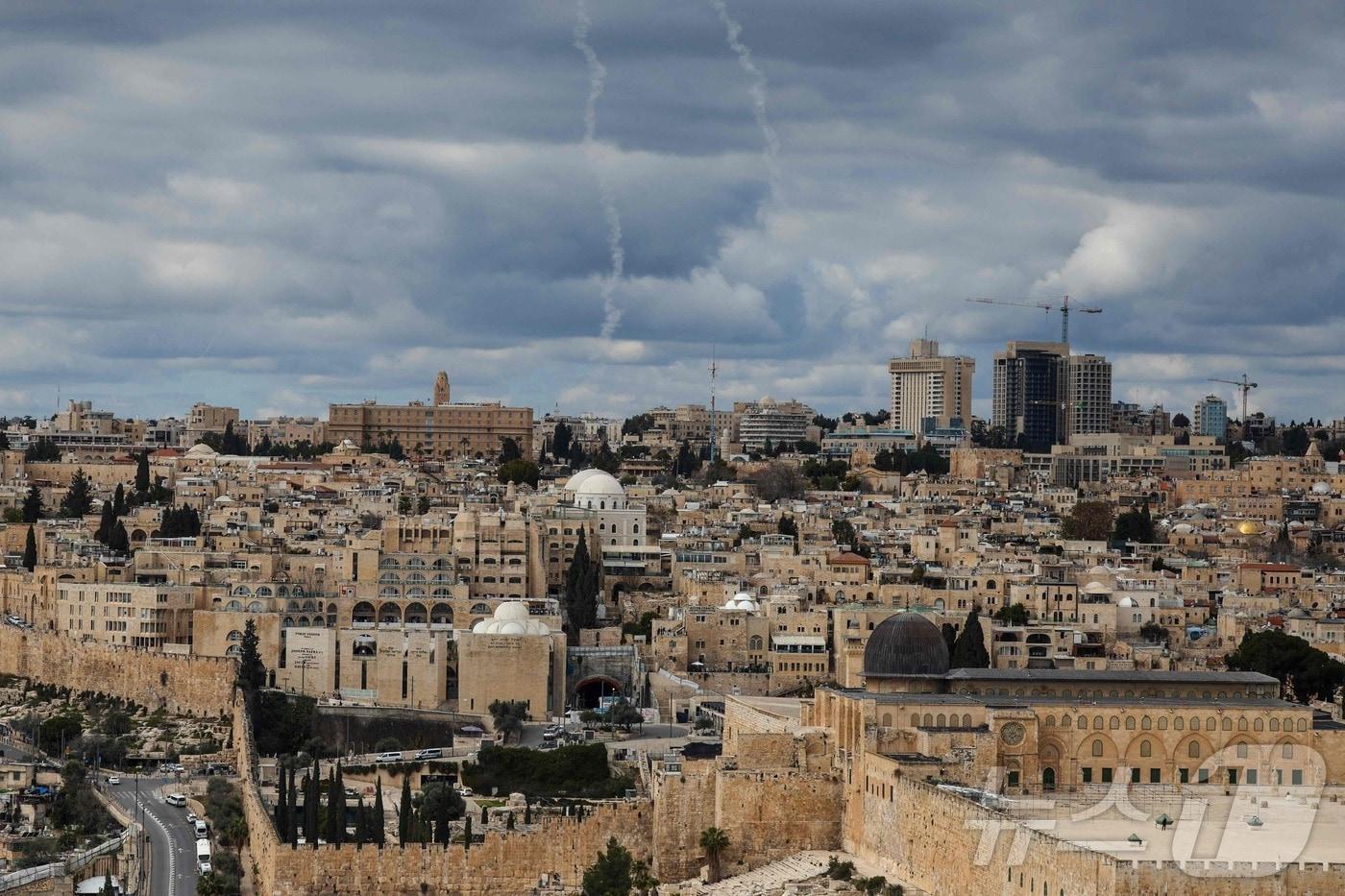본문 이미지 - 미국과 이스라엘이 이란에 대한 공습을 감행한 28일(현지시간) 예루살렘 상공에 이스라엘의 아이언 돔 미사일 방어 시스템에서 발사된 로켓 흔적이 보인다. ⓒ AFP=뉴스1
