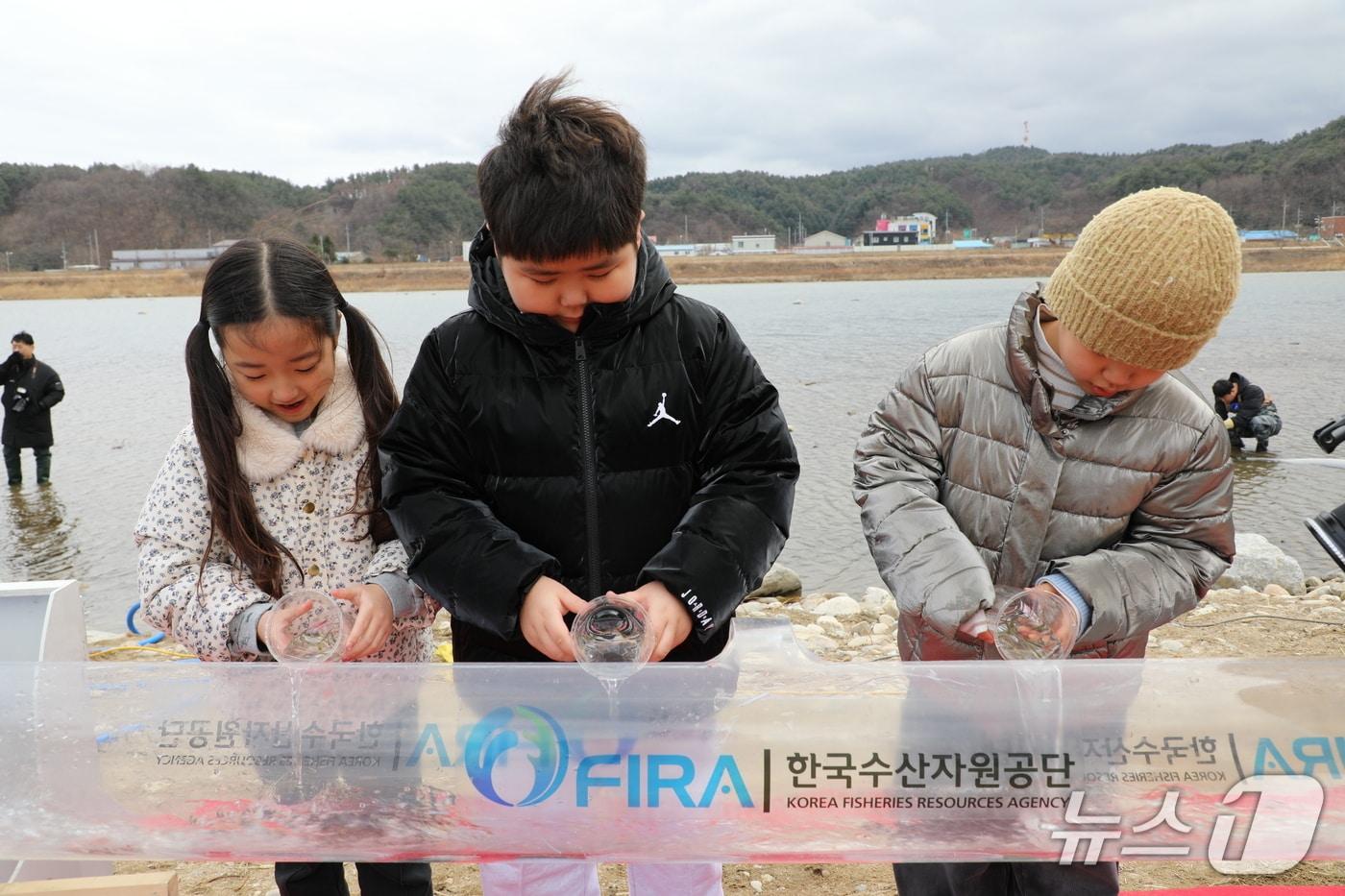 본문 이미지 - 지난 27일 열린 '어린연어 방류행사'에서 방류 체험프로그램에 참여하고 있는 어린이들 (수산자원공단 제공. 재판매 및 DB금지)