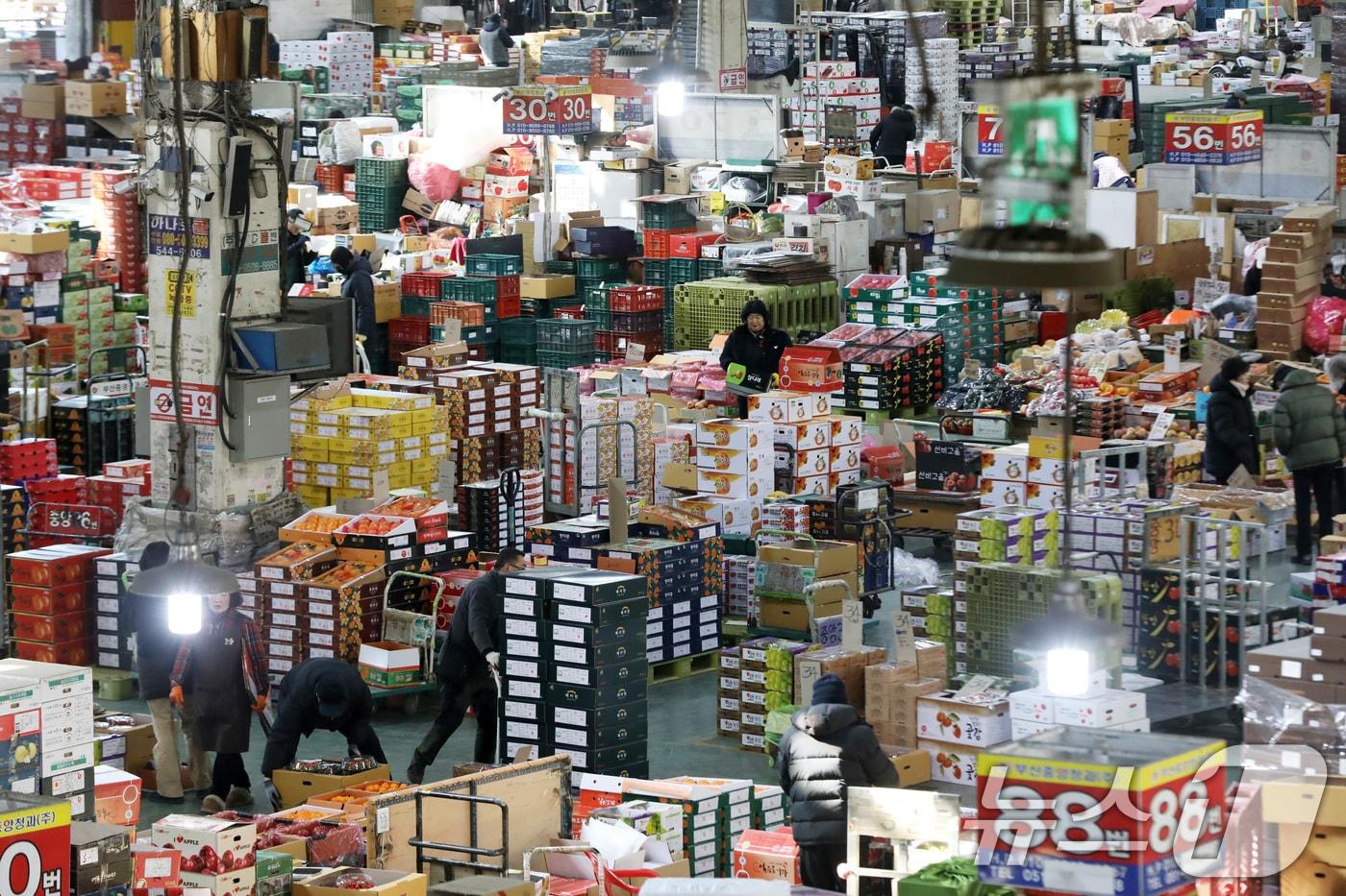 본문 이미지 - 설 명절을 앞둔 3일 부산 해운대구 반여농산물도매시장에서 시민들이 과일을 살펴보고 있다. 2026.2.3 ⓒ 뉴스1 윤일지 기자