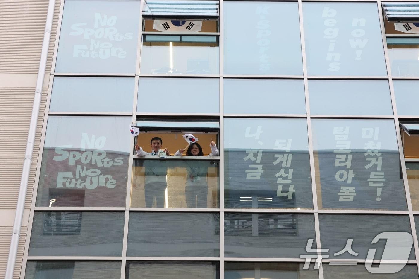 본문 이미지 - 2026 밀라노 코르티나 동계올림픽을 사흘 앞둔 3일(현지시간) 이탈리아 밀라노 올림픽 빌리지에서 바라본 선수촌 창문에서 김택수 선수촌장과 이수경 선수단장이 태극기를 흔들고 있다. 2026.2.3/뉴스1 ⓒ News1 김진환 기자