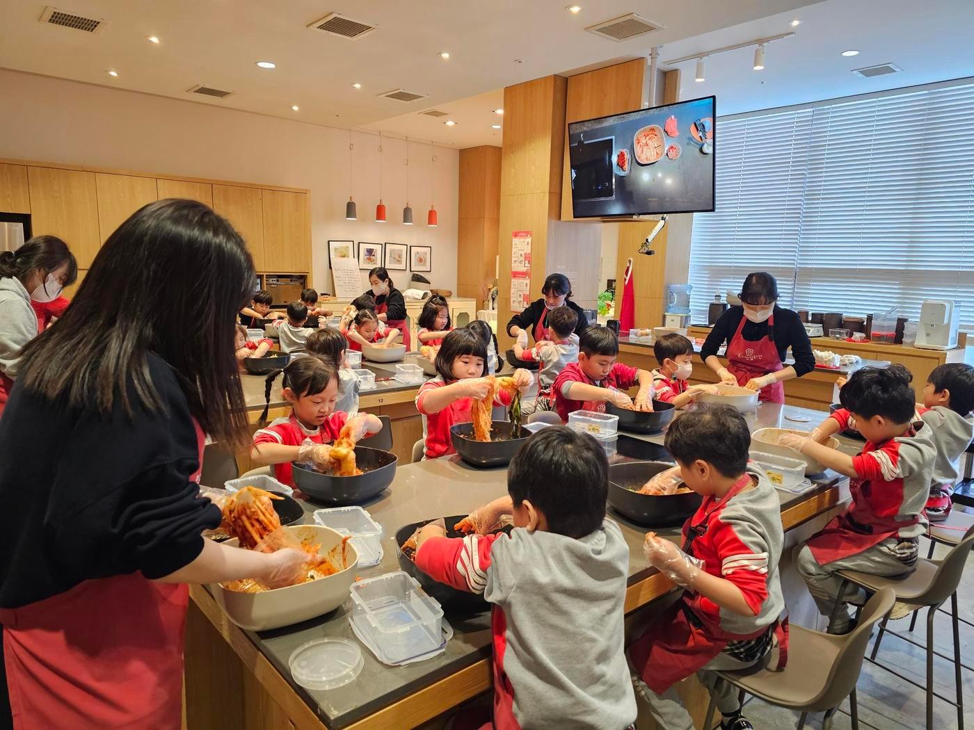 본문 이미지 - 풀무원 뮤지엄김치간의 '어린이 김치학교'에 참여한 어린이와 학부모들이 김치 만들기 체험을 하고 있다.(풀무원 제공)