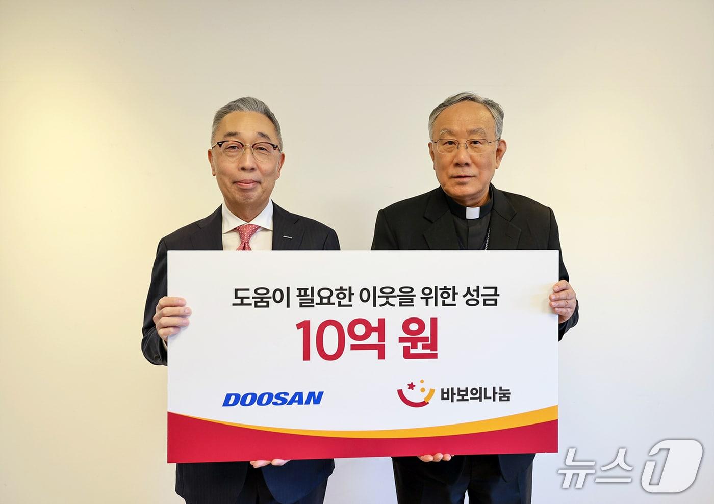 본문 이미지 -  박지원(사진 왼쪽) 두산그룹 부회장과 구요비 재단법인 바보의 나눔 이사장이 3일 서울 명동성당에서 열린 성금 전달식에서 기념촬영을 하고 있다. (사진제공 = 두산그룹)