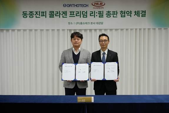 본문 이미지 - 조용호 HLB생명과학 메디케어사업부 사장(사진 오른쪽)과 김일환 올소테크 대표이사가 콜라겐 기반 인체조직 이식재 '프리덤 인젝트 리필'에 대한 국내 총판 계약을 체결한 후 기념촬영을 하고 있다. (HLB생명과학 제공) 