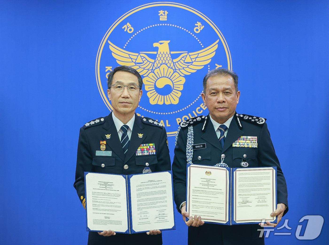 본문 이미지 - 유재성 경찰청장 직무대행(왼쪽)과 모하드 칼리드 빈 이스마일 말레이시아 경찰청장이 4일 오전 서울 서대문구 경찰청에서 열린 '초국가범죄 대응을 위한 양해각서(MOU)' 체결식 이후 기념사진을 촬영하고 있다.(경찰청 제공)