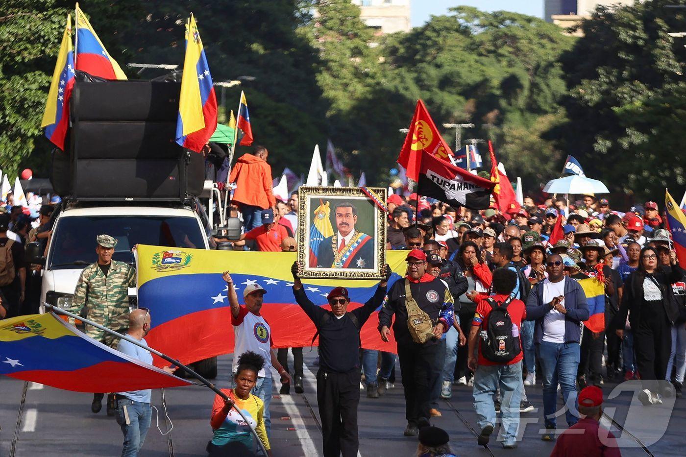 본문 이미지 - 니콜라스 마두로 베네수엘라 대통령과 실리아 플로레스 영부인이 축출된 지 한 달 뒤인 3일(현지시간) 카라카스에서 정부 지지자들이 행진하고 있다. 2026.02.03. ⓒ AFP=뉴스1 ⓒ News1 이정환 기자