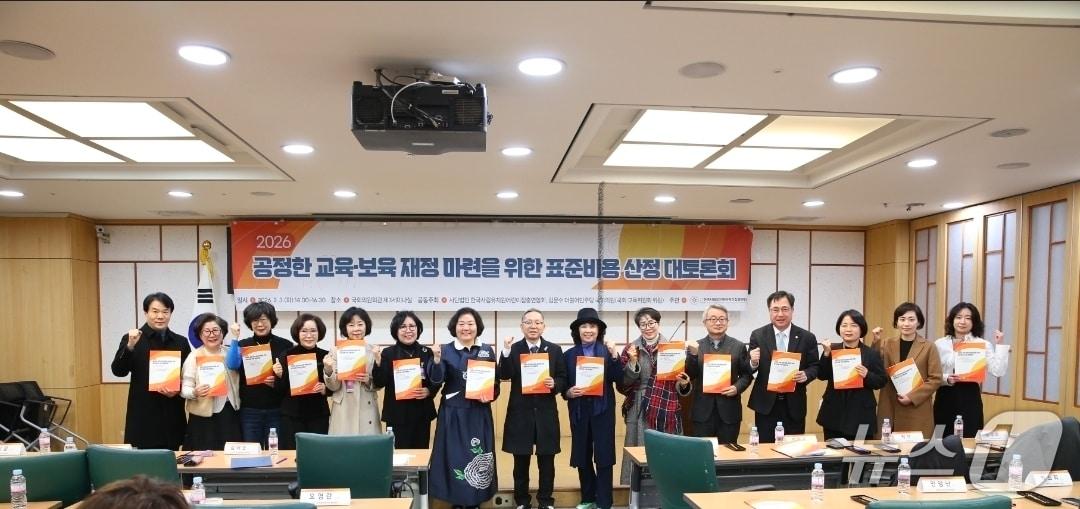 본문 이미지 -  국회의원회관 제3세미나실에서 열린 ‘공정한 교육·보육 재정 마련을 위한 표준비용 산정 대토론회’에서 참석자들이 자료를 들고 기념촬영을 하고 있다.(한사총 제공)