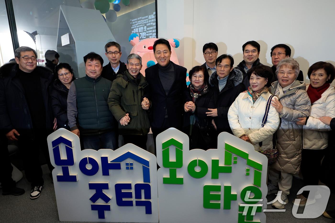 본문 이미지 - 오세훈 서울시장이 지난 2월 4일  서울시 중구 세종대로 서울도시건축전시관에서 열린 행사에서 기념 촬영을 하고 있다. 모아타운은 대규모 재개발이 어려운 노후 저층 주거지를 블록 단위로 묶어 아파트처럼 공동 개발하는 서울시의 소규모 주택 정비 모델이다. 2026.2.4 ⓒ 뉴스1 박정호 기자