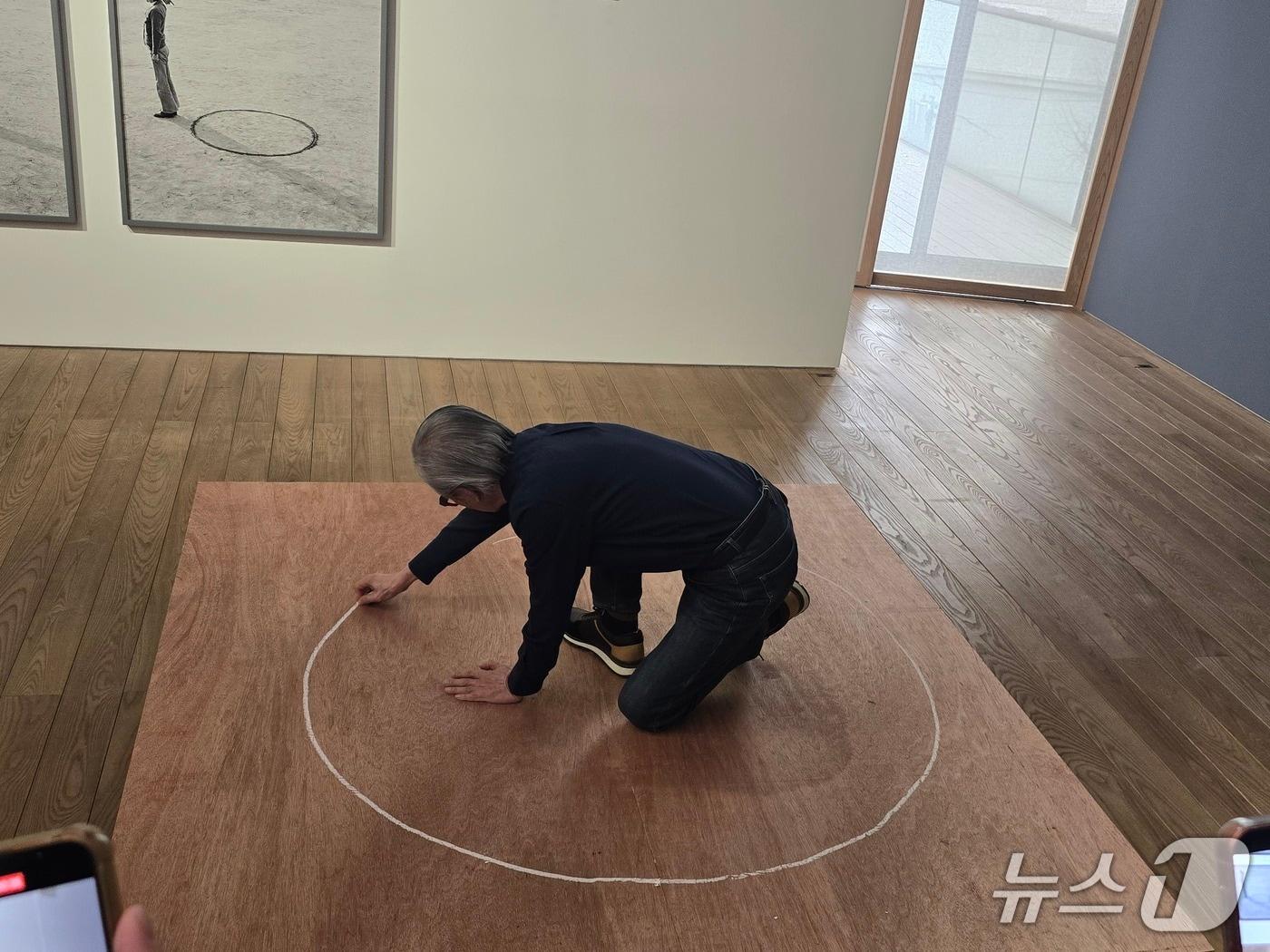 본문 이미지 - 4일 열린 기자간담회에서 이건용 작가는 직접 원을 그리고 행위를 선보이는 퍼포먼스를 선보이고 있다. ⓒ 뉴스1 김정한 기자