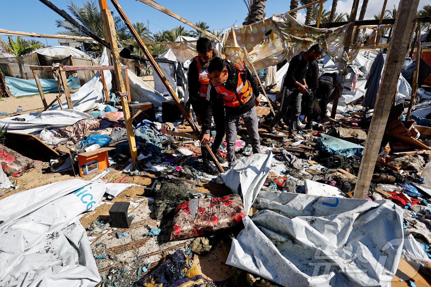 본문 이미지 - 4일(현지시간) 팔레스타인 가자 지구 남부 칸유니스에서 민방위 대원들이 이스라엘 공습을 받은 피난민 캠프를 점검하고 있다. 2026.02.04. ⓒ 로이터=뉴스1 ⓒ News1 윤다정 기자