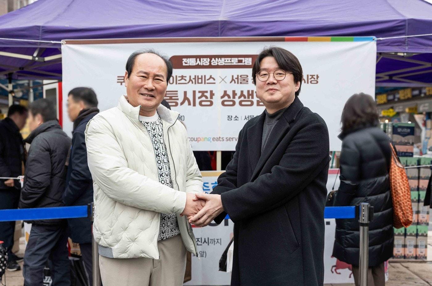 본문 이미지 -  정우윤 쿠팡이츠서비스 대외정책실 실장(오른쪽)과 유완희 청량리종합시장 상인회장이 5일 청량리에서 열린 쿠팡·쿠팡이츠서비스 X 전통시장 상생협력을 기념하고 있다.(쿠팡 제공). 