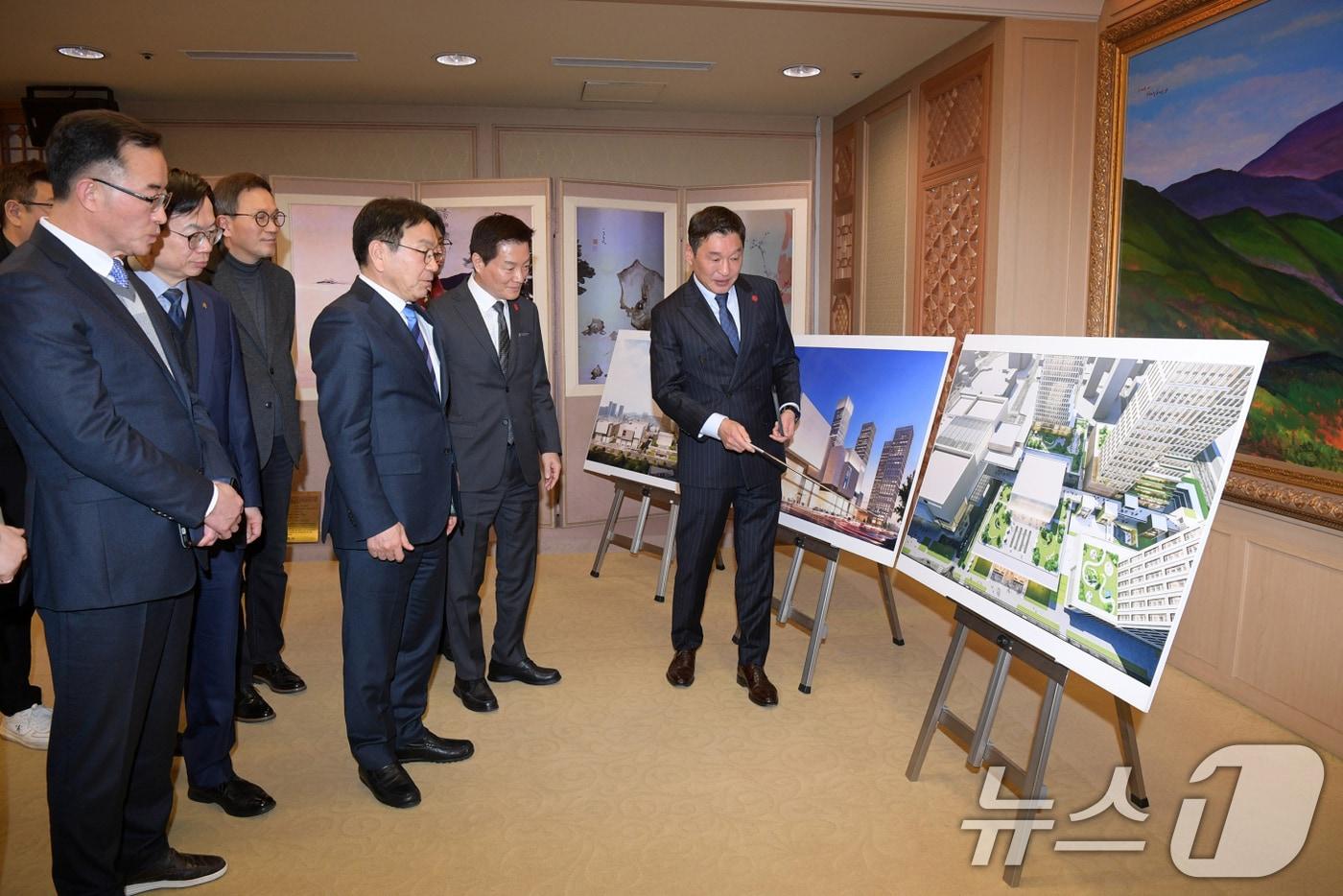 본문 이미지 - 강기정 광주광역시장이 5일 오전 시청 비즈니스룸에서 박주형 ㈜신세계 대표이사와 광천터미널 복합화사업 투자양해각서를 체결한 후 이동훈 광주신세계 대표로부터 조감도에 대한 설명을 듣고 있다. (광주광역시 제공. 재판매 및 DB 금지) 2026.2.5/뉴스1 