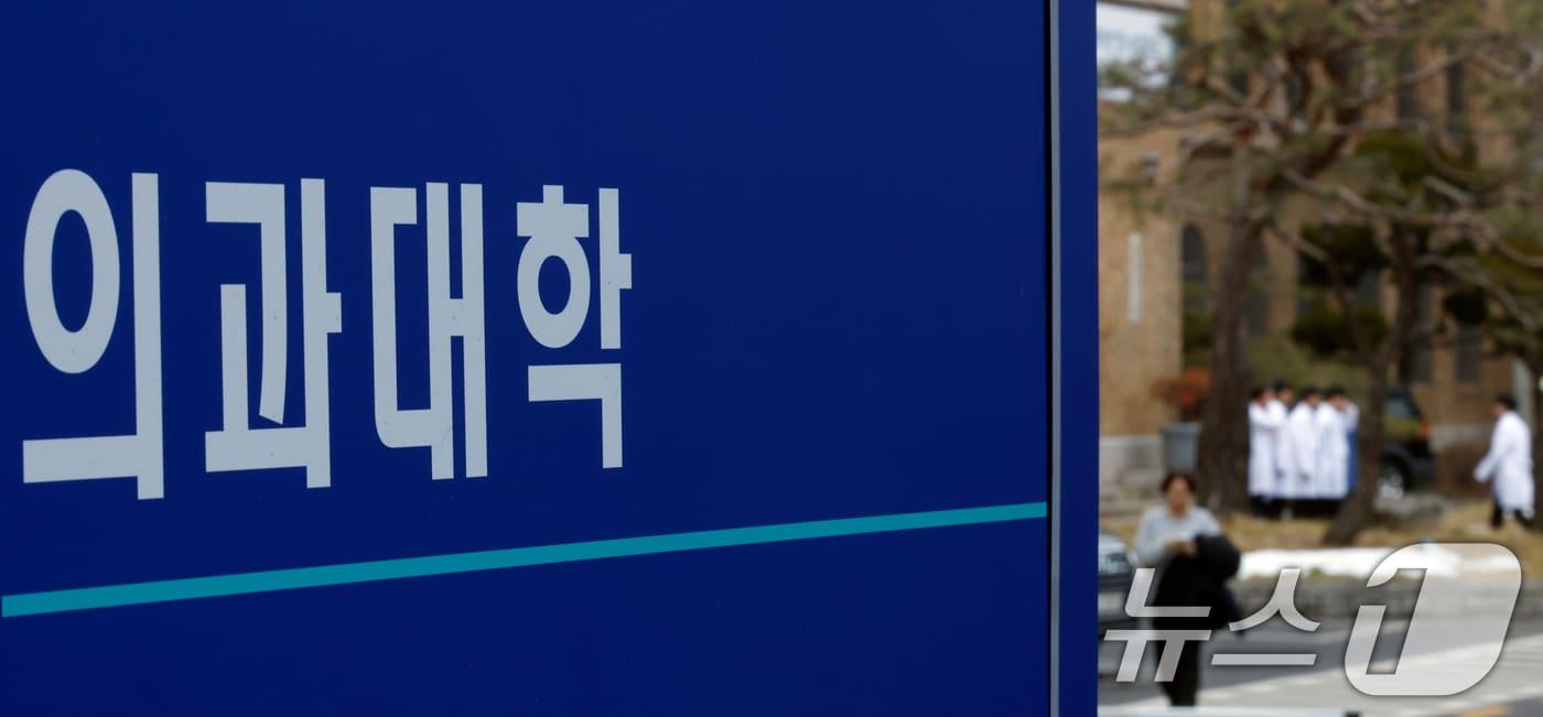 본문 이미지 - 서울의 한 의과대학 앞에 가운을 입은 학생들이 모여 있다. ⓒ 뉴스1 