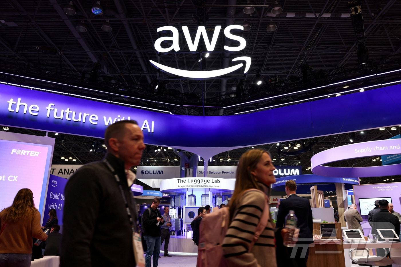 본문 이미지 - 1월 12일(현지시간) 미국 뉴욕에서 열린 미국소매협회(NRF) 리테일 빅 쇼에서 사람들이 아마존웹서비스(AWS) 전시관 앞을 지나고 있다. 2026.01.12. ⓒ 로이터=뉴스1 ⓒ News1 윤다정 기자