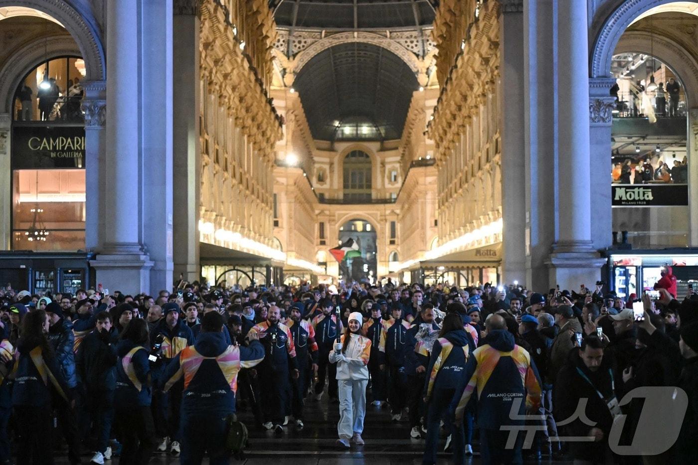 본문 이미지 - 2026 밀라노·코르티나담페초 동계 올림픽 개회식을 하루 앞둔 이탈리아 밀라노에서 진행 중인 성화 봉송. ⓒ AFP=뉴스1