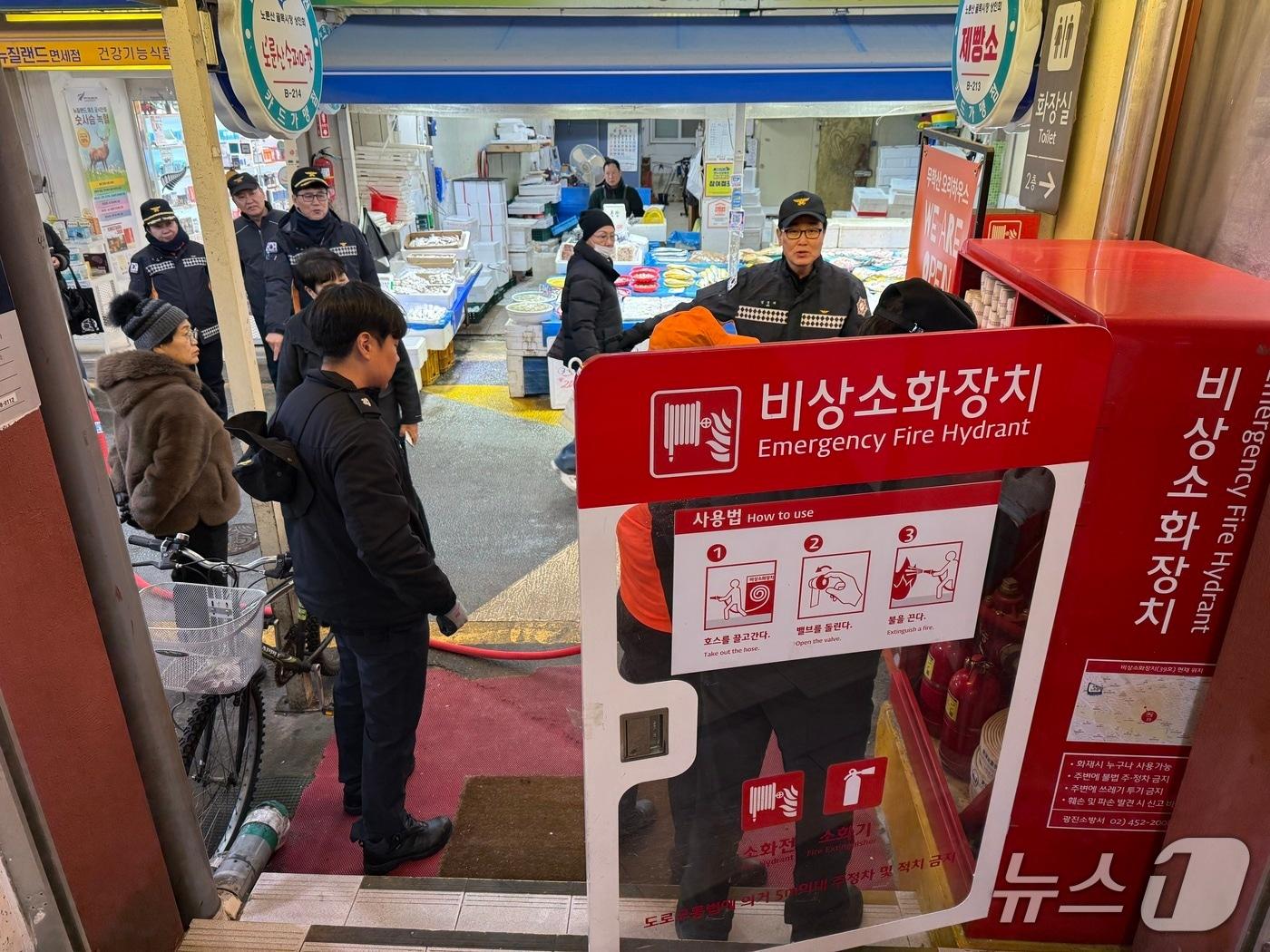 본문 이미지 - 전통시장에서 비상소화장치를 점검하고 있다.(서울시 제공)