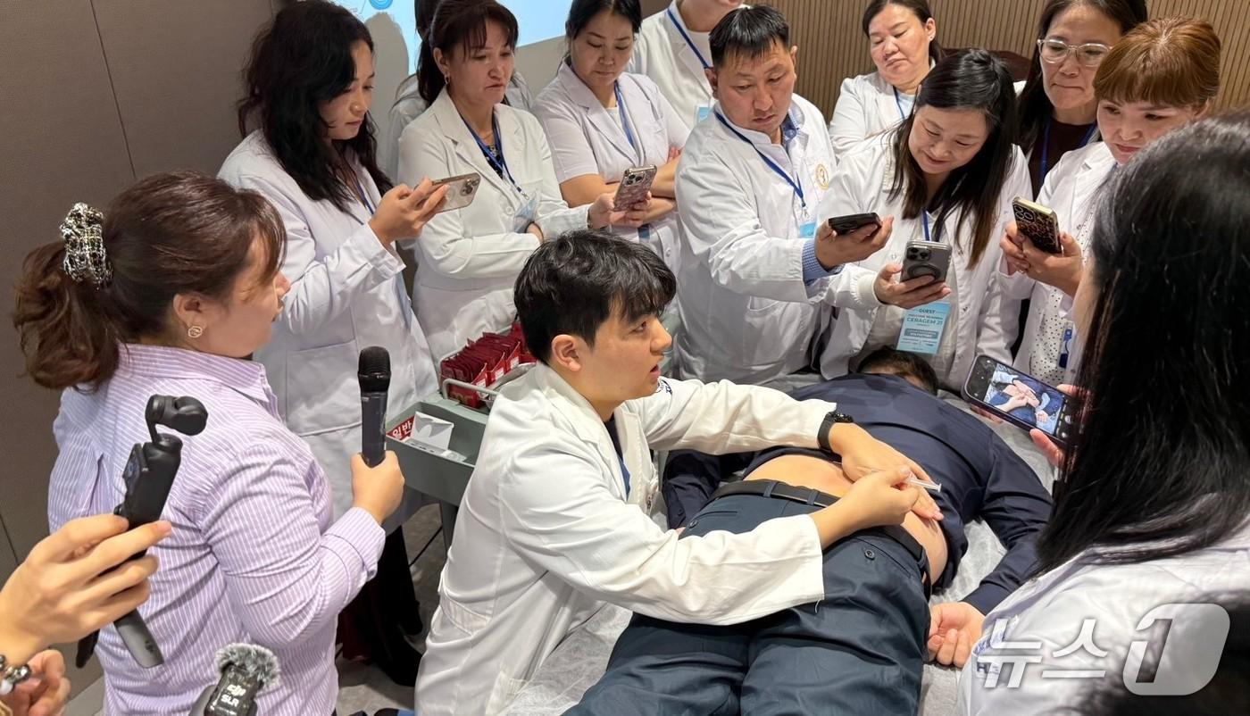 본문 이미지 - '자생한방병원 한의 치료법 설명회'에 참여한 몽골 의료진들이 한의통합치료 시연 강의를 듣고 있다.(자생한방병원 제공)