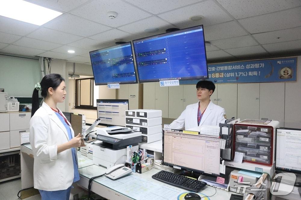 본문 이미지 - 의료진이 스마트 병상 모니터링 시스템 '씽크'로 환자 상태를 확인하고 이야기를 나누고 있다.(대웅제약 제공)