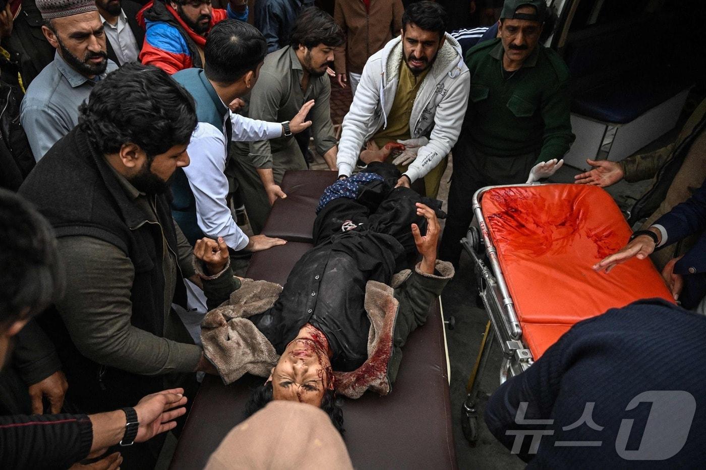 본문 이미지 - 6일(현지시간) 파키스탄 이슬라마바드 이슬람 사원 테러로 부상을 입은 남성이 병원으로 이송되고 있다. 2026.02.06 ⓒ AFP=뉴스1