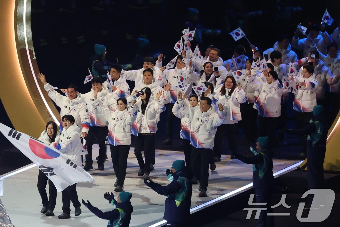 본문 이미지 - 대한민국 선수단 기수 차준환(피겨 스케이팅)과 박지우(스피드 스케이팅)가 6일 오후(현지시간) 이탈리아 밀라노 산시로 올림픽 스타디움에서 열린 2026 밀라노·코르티나담페초 동계올림픽대회 개회식에서 선수단을 이끌고 입장하고 있다. 2026.2.7 ⓒ 뉴스1 김진환 기자