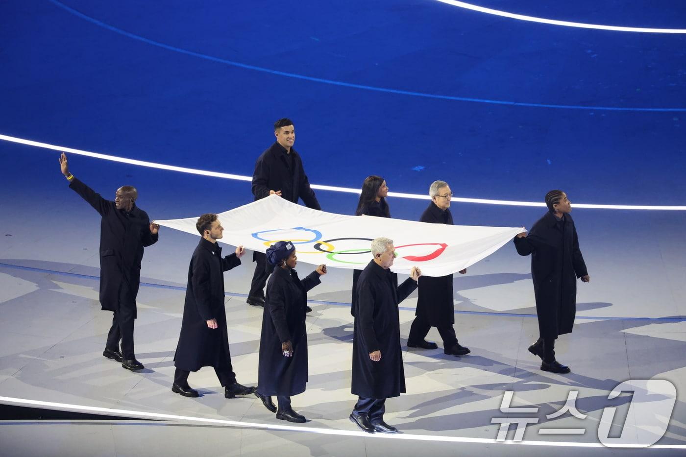 본문 이미지 - 6일 오후(현지시간) 이탈리아 밀라노 산시로 올림픽 스타디움에서 열린 2026 밀라노·코르티나담페초 동계올림픽대회 개회식에서 올림픽기가 입장하고 있다. 2026.2.7 ⓒ 뉴스1 김진환 기자