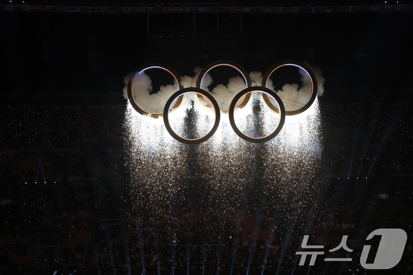 본문 이미지 - 6일 오후(현지시간) 이탈리아 밀라노 산시로 올림픽 스타디움에서 열린 2026 밀라노·코르티나담페초 동계올림픽대회 개회식에서 이탈리아 알파인 스킨 레전드 데보라 콤파뇨니, 엘베르토 톰바가 성화를 점화하자 오륜기 로고 조형물에서 불꽃이 터지고 있다. 2026.2.7 ⓒ 뉴스1 김성진 기자